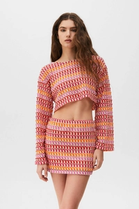 Gros plan détaillé sur la texture crochetée à motifs ondulés du haut court et de la jupe
