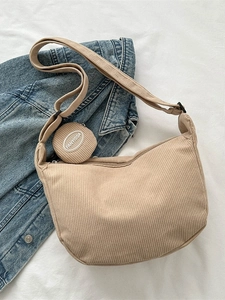 Khaki corduroy dumpling crossbody bag with round coin purse on denim background