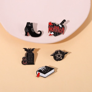 Gothic enamel pin set with tombstone and horror book motifs for Halloween decor