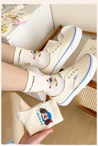 Detail of cream mid-calf cotton socks with cartoon puppy motif and soft knit texture