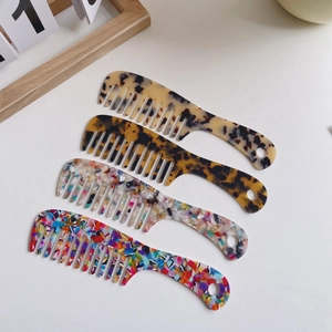 Four elegant acetate wide-tooth hair combs with marble and tortoiseshell patterns