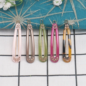 Set of five waterdrop acetate hair clips with rhinestones on checkered background