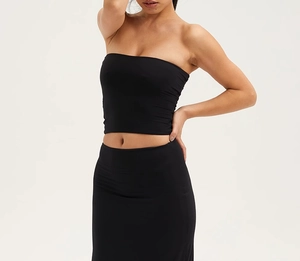 Détail d'un haut bandeau noir sans couture et d'une jupe longue assortie en maille stretch