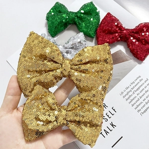 Close-up of sparkling sequin bow hair clips in vibrant colors on a magazine background
