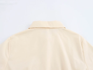 Detailaufnahme von Kragen und Schulterpartie des beigen Kleides aus Baumwollleinen