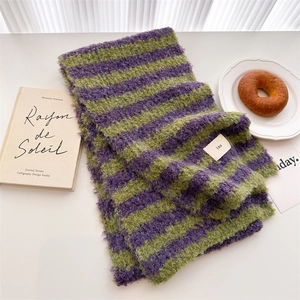 Soft striped wool knit scarf in purple and green on a minimalist table setting