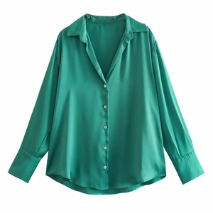 Détail de la chemise en satin vert émeraude montrant la texture lisse et le col