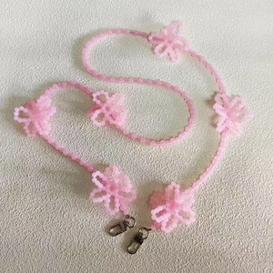 Detailed view of handmade pink beaded lanyard with decorative flowers and silver lobster clasps