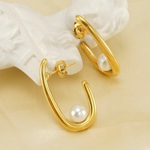 Elegant 18K gold-plated U-shaped earrings with white pearls on a satin background