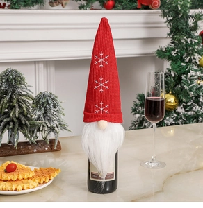 Detail of red knit gnome wine bottle cover with snowflake embroidery and white faux beard