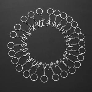 Set aus 26 Buchstaben-Schlüsselanhängern aus Edelstahl auf dunkelgrauem Hintergrund