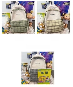 Close-up of three plaid backpacks in green, khaki, and grey with grid canvas patchwork