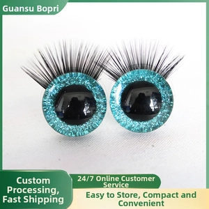 Close-up of glitter blue 3D craft doll eyes with thick long black eyelashes for toy making