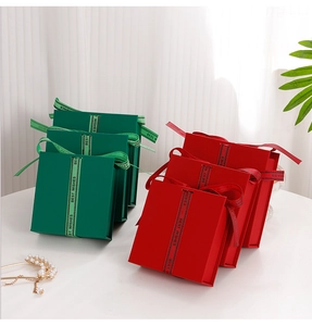 Detail of square flip gift boxes in red and green with 'Best Wishes' ribbon bows