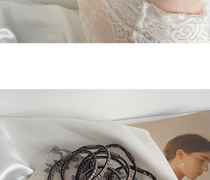 Detailed close-up of leopard pattern seamless hair ties on white silk fabric background