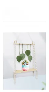 Détail de l'étagère en bois bohème avec feuilles en macramé vert et pot de plante