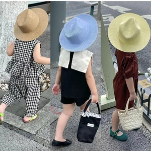 Handmade woven sun hats and summer outfits for kids in stylish outdoor street settings