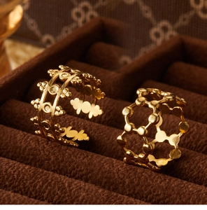 Detailed close-up of two vintage style 18K gold plated hollow floral pattern rings
