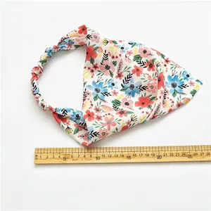 Foulard fleuri avec bande élastique et règle en bois montrant la taille sur fond blanc