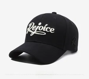 Detailed view of the 3D embroidered Rejoice lettering on a black cotton baseball cap