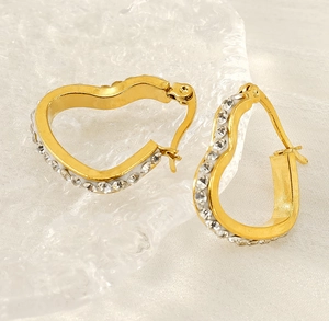 Close-up of 18k gold plated heart earrings featuring side-set crystals on clear ice