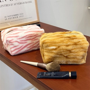 Fuzzy plush cosmetic bags in pink zebra and tiger stripes for travel storage
