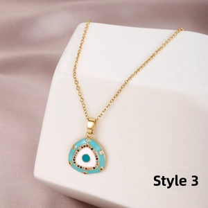 Detailed macro view of gold evil eye triangle pendant with colorful zirconia settings