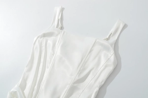 Dettaglio del corsetto in raso bianco con spalline regolabili e consistenza setosa lucida