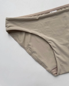 Close-up of seamless stitching and elastic edges on beige ice silk panties for women