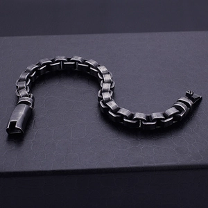 Détail d'un bracelet industriel en acier vintage avec maillons carrés sur cuir noir