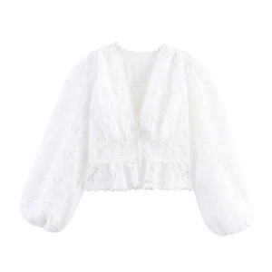 Detailed view of white lace V-neck blouse with elegant puff sleeves and floral texture