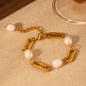 18K gold plated stainless steel paperclip bracelet with freshwater pearls on beige fabric