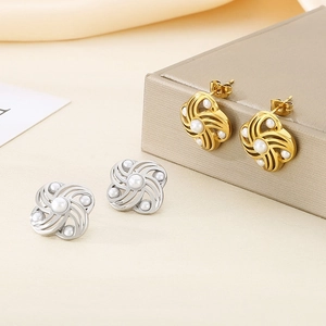 Detail of floral earrings with shell pearls in gold and silver finish on jewelry box