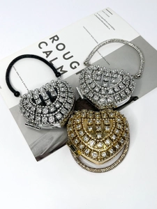 Detailed view of heart-shaped evening bags in silver, gold, and black with rhinestones