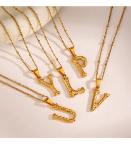 Detail of gold square initial pendants with bark texture and twisted chain necklace