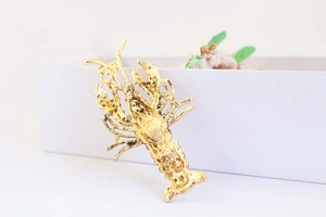 Detailed back view of gold lobster keychain showing honeycomb texture and pendant ring