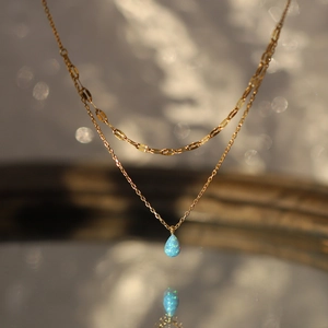 Vue détaillée du collier double couche plaqué or 18K avec un pendentif opale bleue
