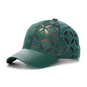 Détail de la casquette avec bord en cuir vert et broderie à motif monogramme
