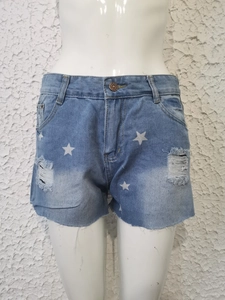 Detailopname van lichtblauwe denim shorts met sterrenprint en gerafelde gescheurde zoom