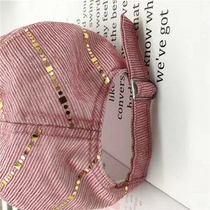 Detailed macro view of pink sequined baseball cap with adjustable metal buckle back