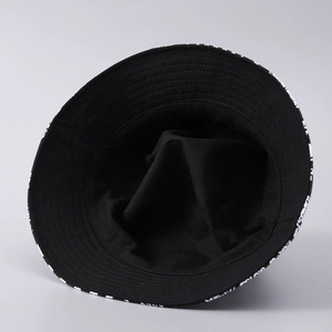 Detailed view of the internal stitching and white letter print on a black bucket hat