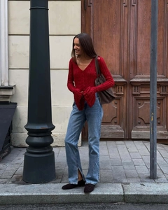 Detail of red V-neck knit cardigan with flared sleeves and hollow out texture