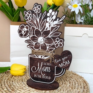 Detail of wooden flower ornament with The Best Mom In The World engraving on woven mat