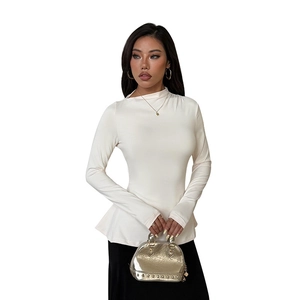 Haut blanc élégant à manches longues avec col montant et style minimaliste et raffiné