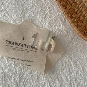 Close-up of pearl white acetate hair claw clip with handmade engraving on the side