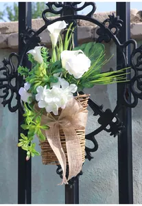 Detail eines hängenden Weidenkorbs mit weißen Calla-Lilien und Sackleinen-Schleife