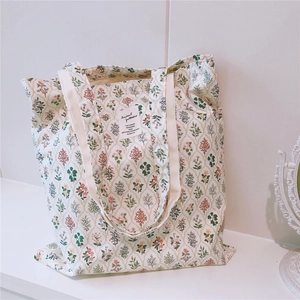 Close-up of floral cotton tote bag showing dense flower patterns and square fabric label