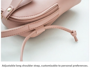 Detail of adjustable long shoulder strap and zipper on light pink mini crossbody bag