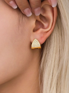 Macro shot of triangle gold earrings with pavé zircons worn by a model to show detail