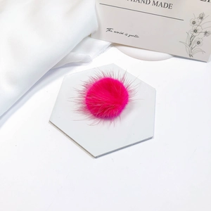 Close-up of fluffy pink faux fur pompom ball for DIY craft accessories and hair decorations